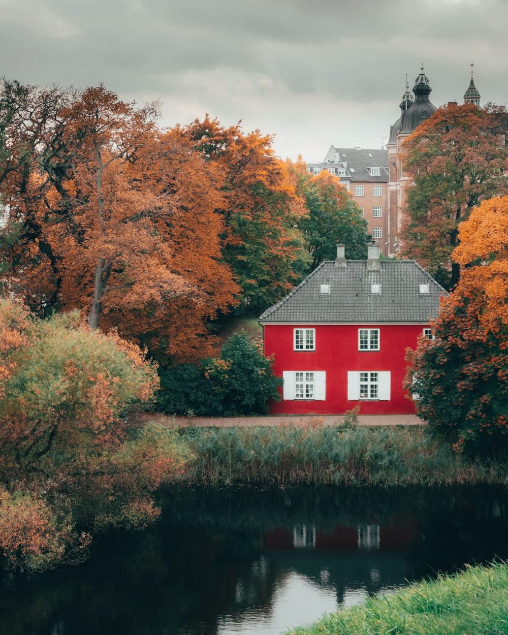 a red house sitting next to a body of water