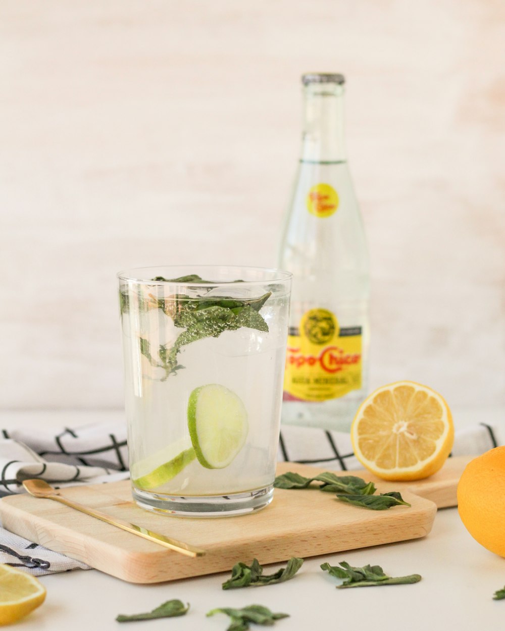 a bottle of lemonade and a glass of lemonade on a cutting board