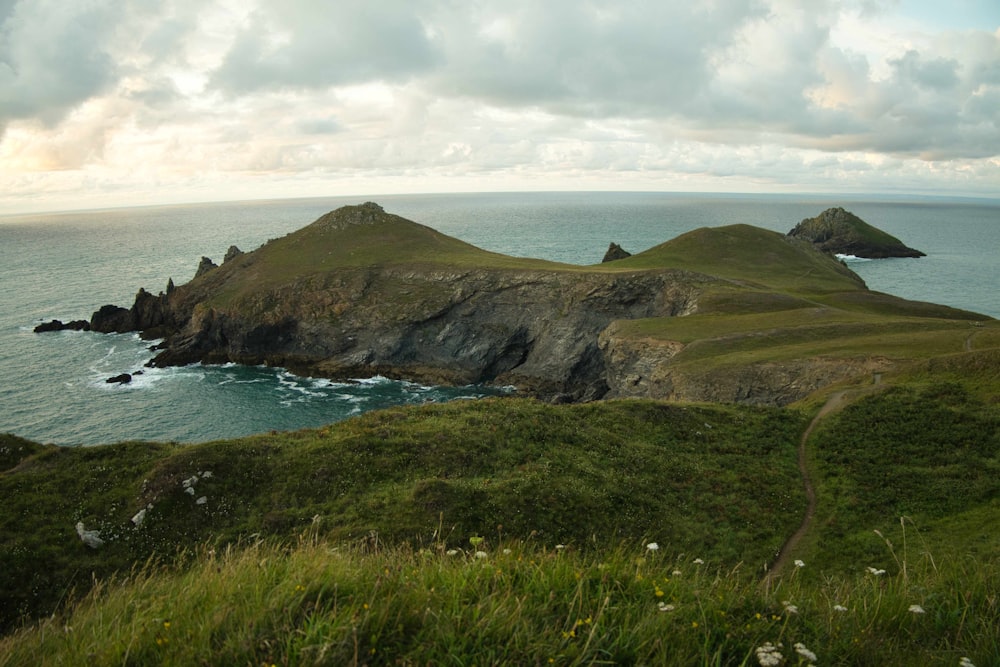 a grassy hill next to a body of water