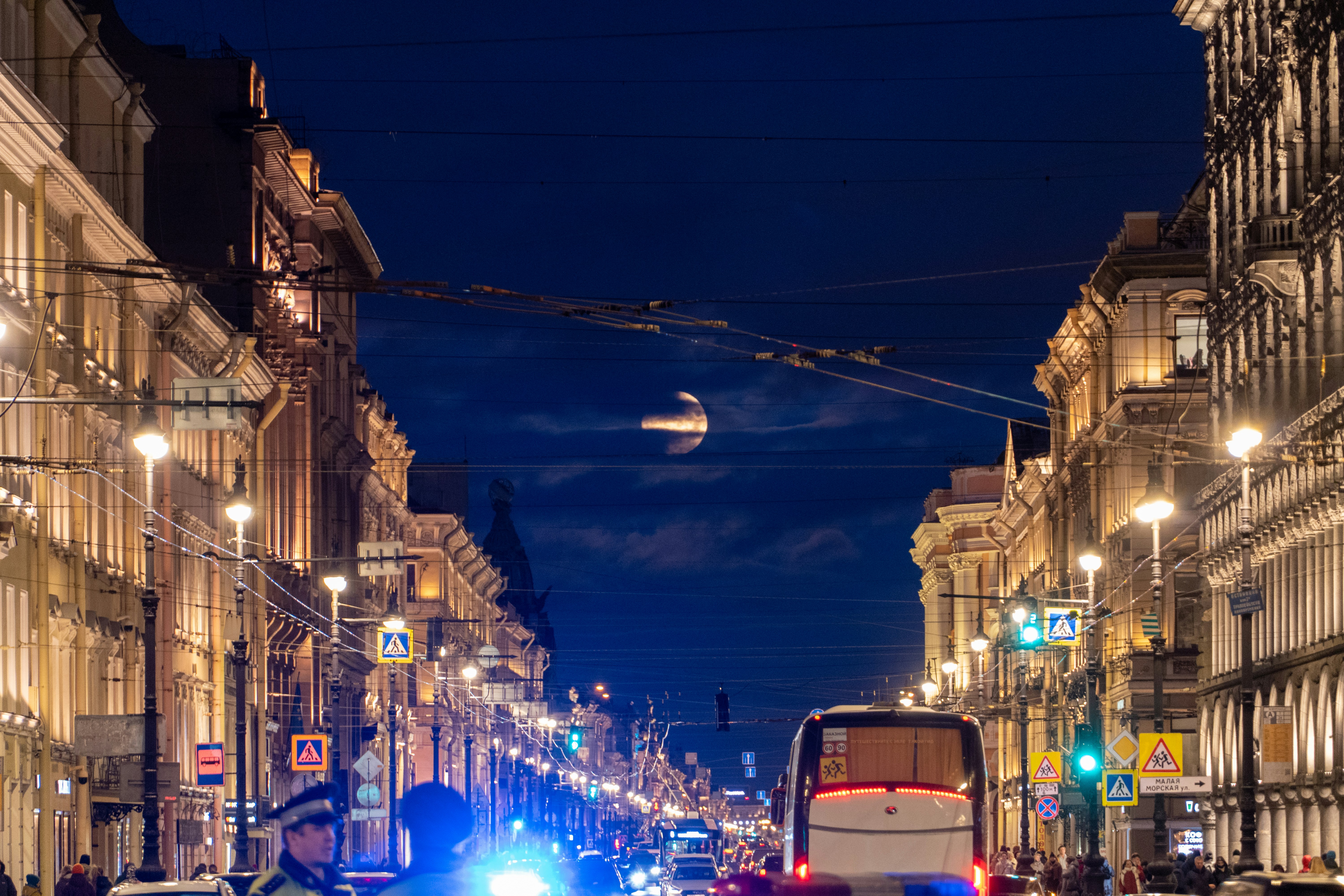 a double decker bus driving down a street at night