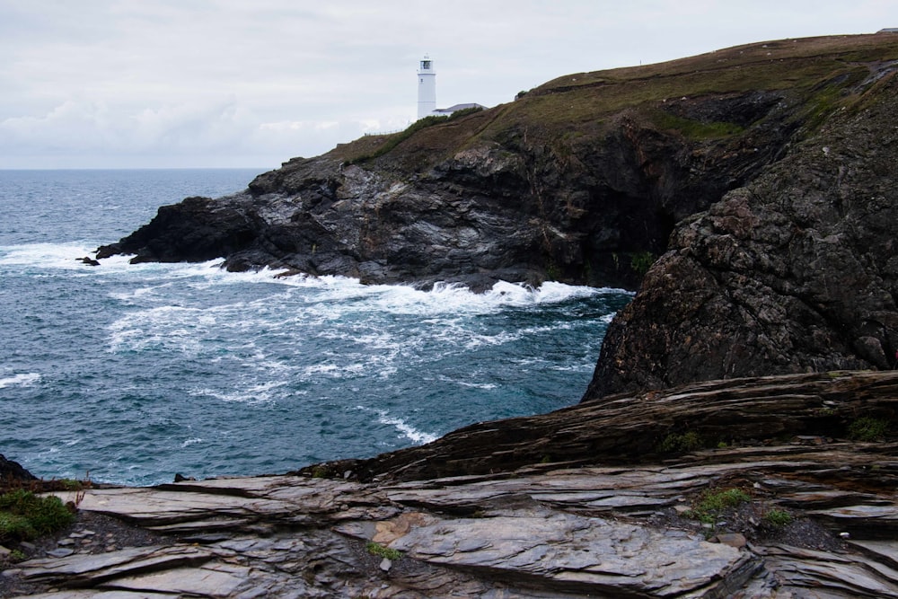 a lighthouse on top of a cliff near the ocean