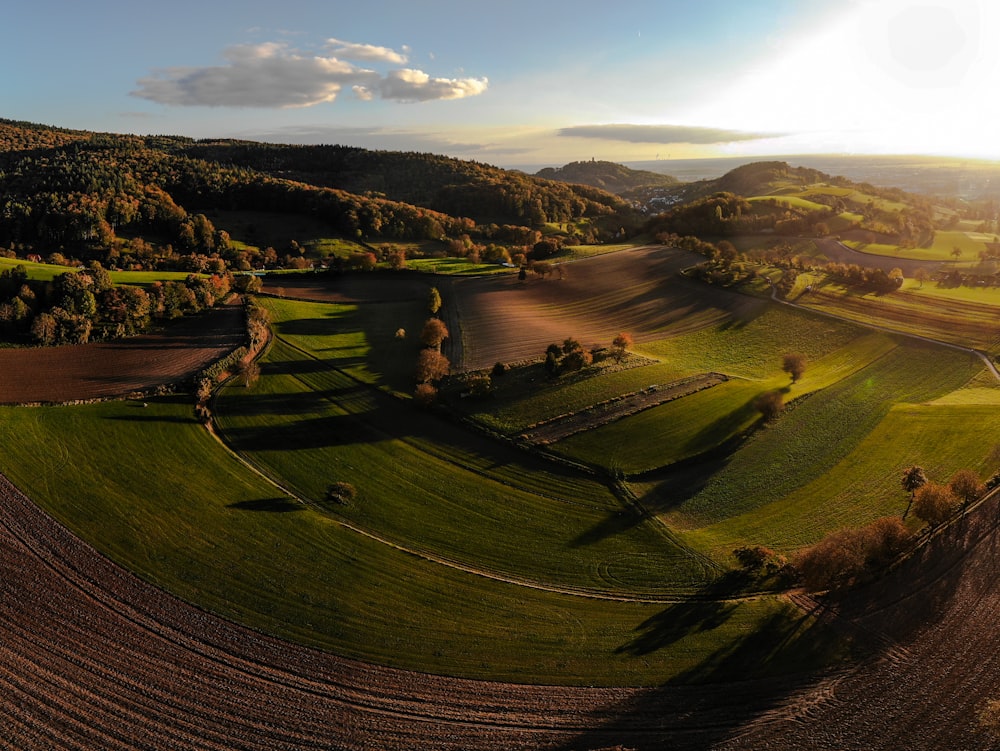 an aerial view of a farm with rolling hills in the background