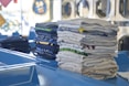 a stack of folded shirts sitting on top of a blue table