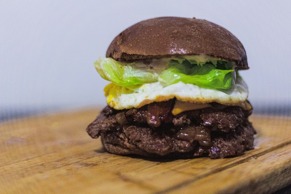 a close up of a hamburger on a wooden table