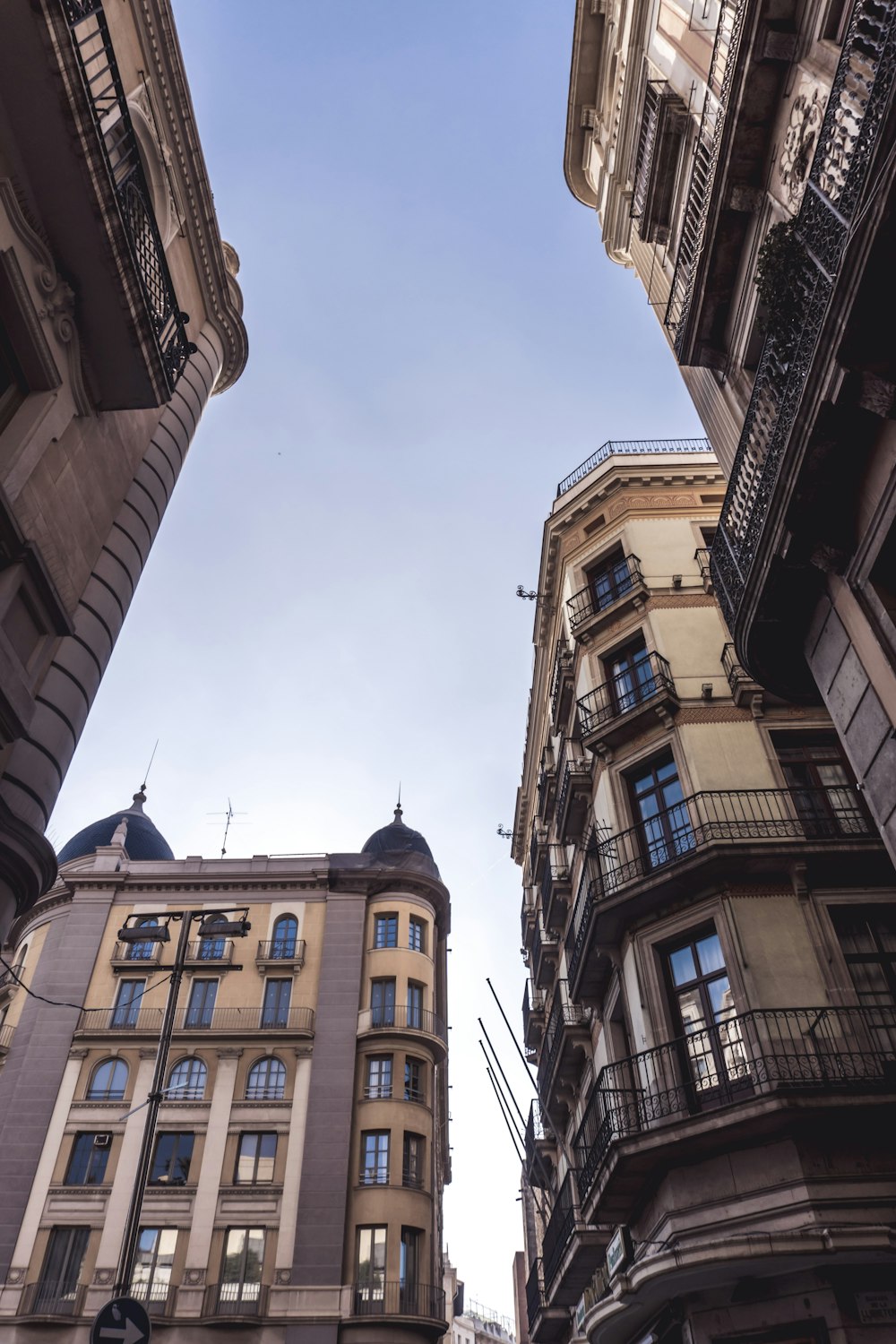 looking up at tall buildings with balconies and balconies