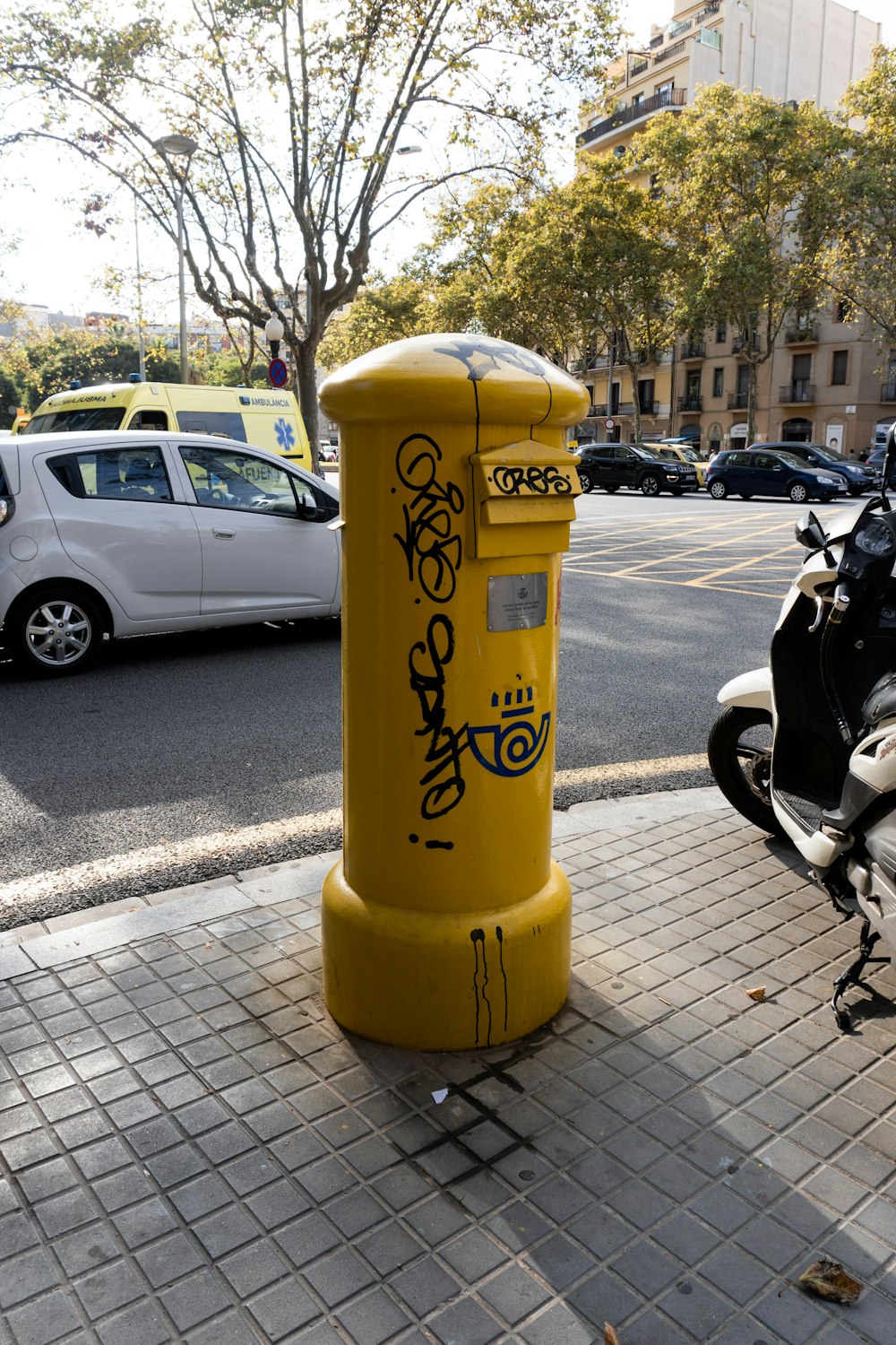 a yellow fire hydrant sitting on the side of a road