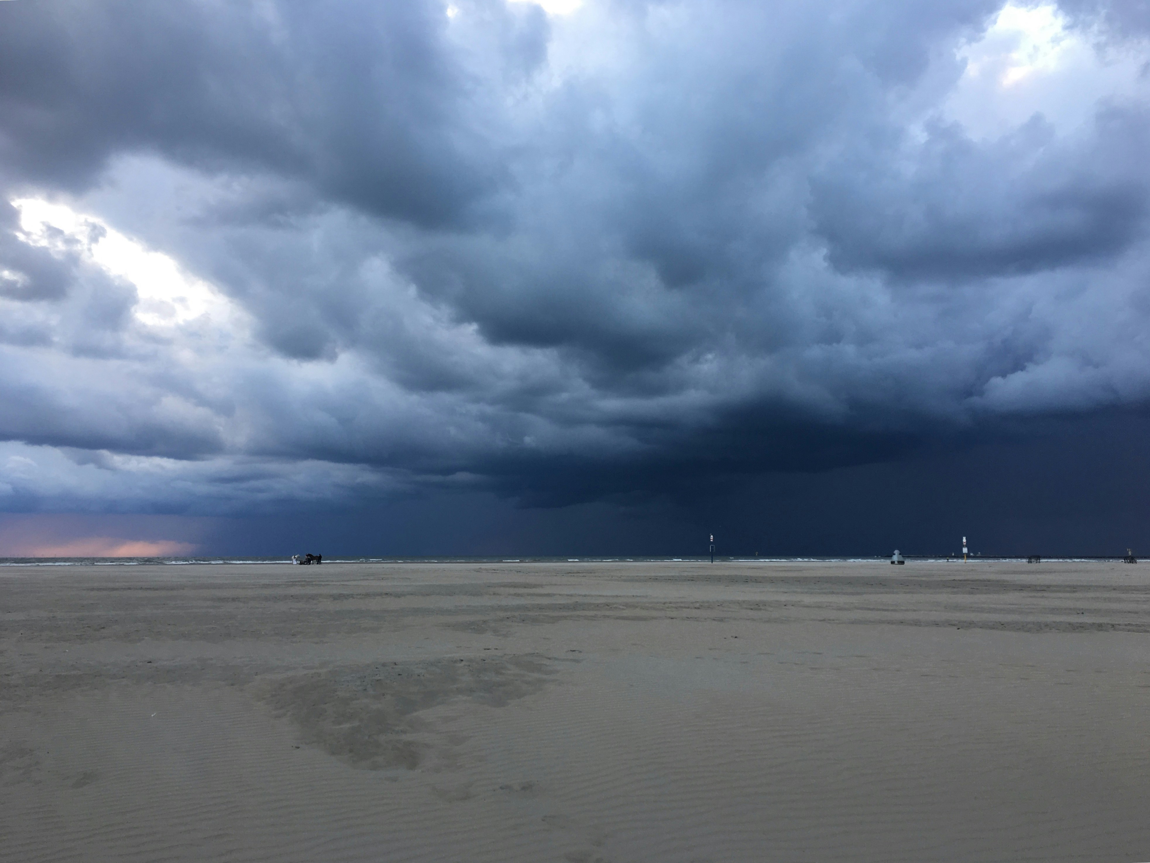 a beach with a lot of dark clouds in the sky