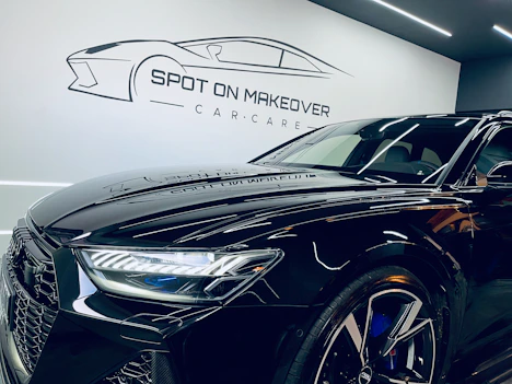 A sleek vehicle gleaming under sunlight after a detailed cleaning service outdoors