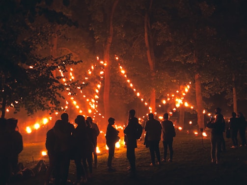 A serene group of people holding lanterns in a peaceful forest at twilight, symbolizing guidance and unity.