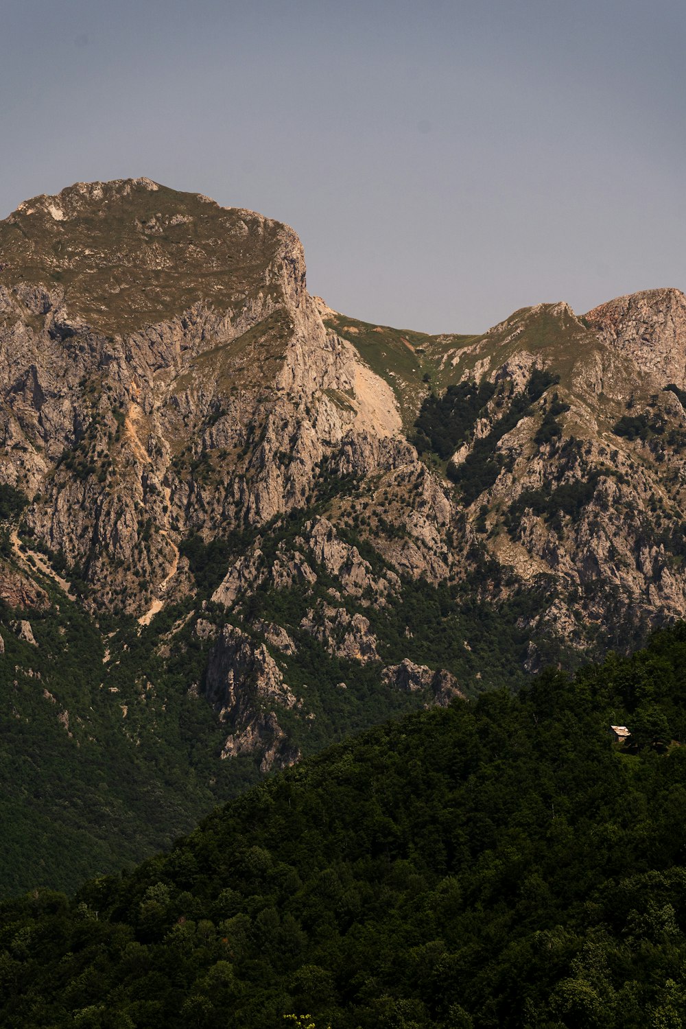 a mountain range with a house in the foreground