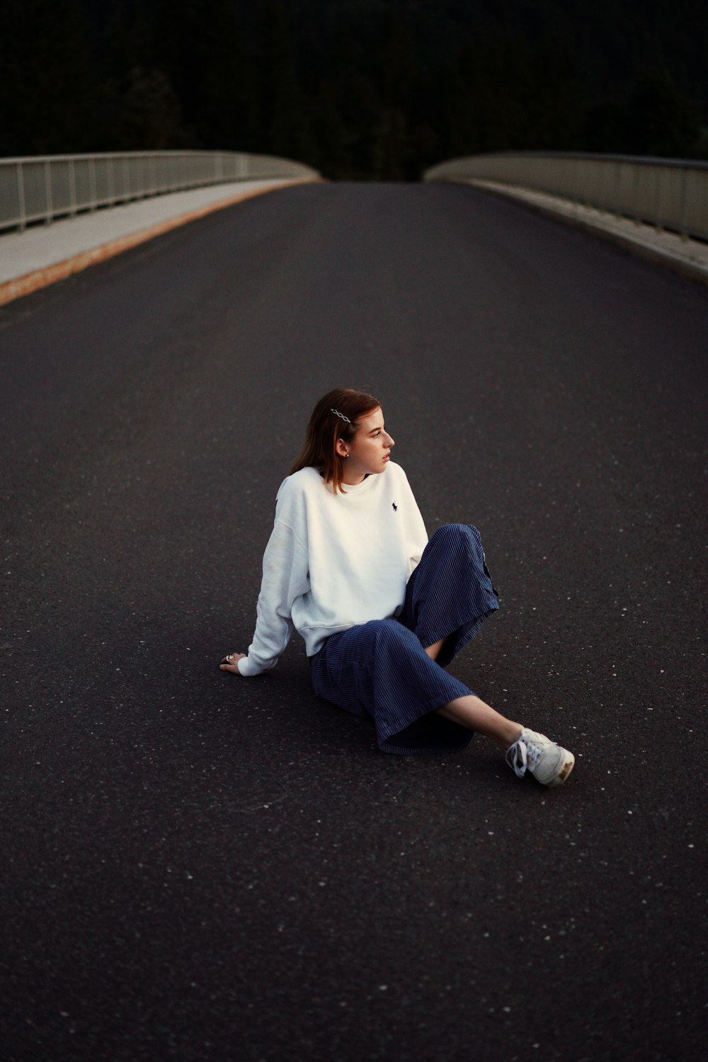 a woman sitting on the side of a road