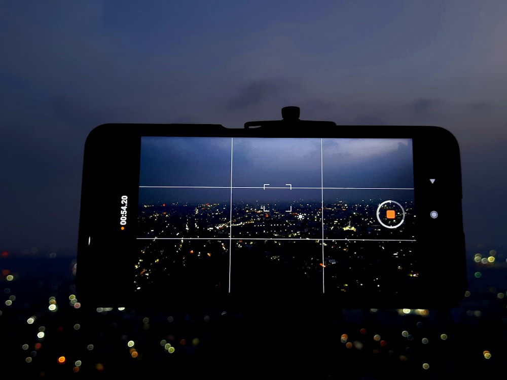 Una persona tomando una foto de una ciudad por la noche