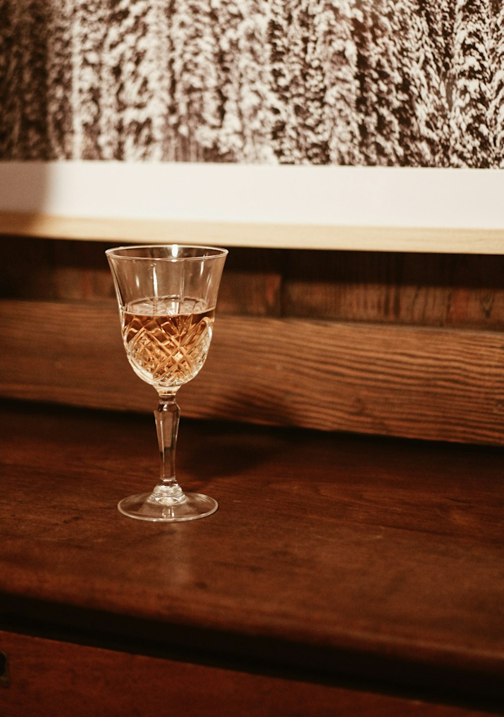 a glass of wine sitting on top of a wooden table