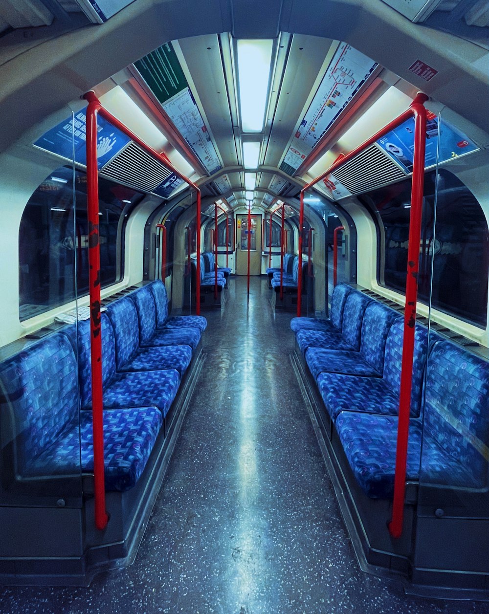 a train car with blue seats and red rails