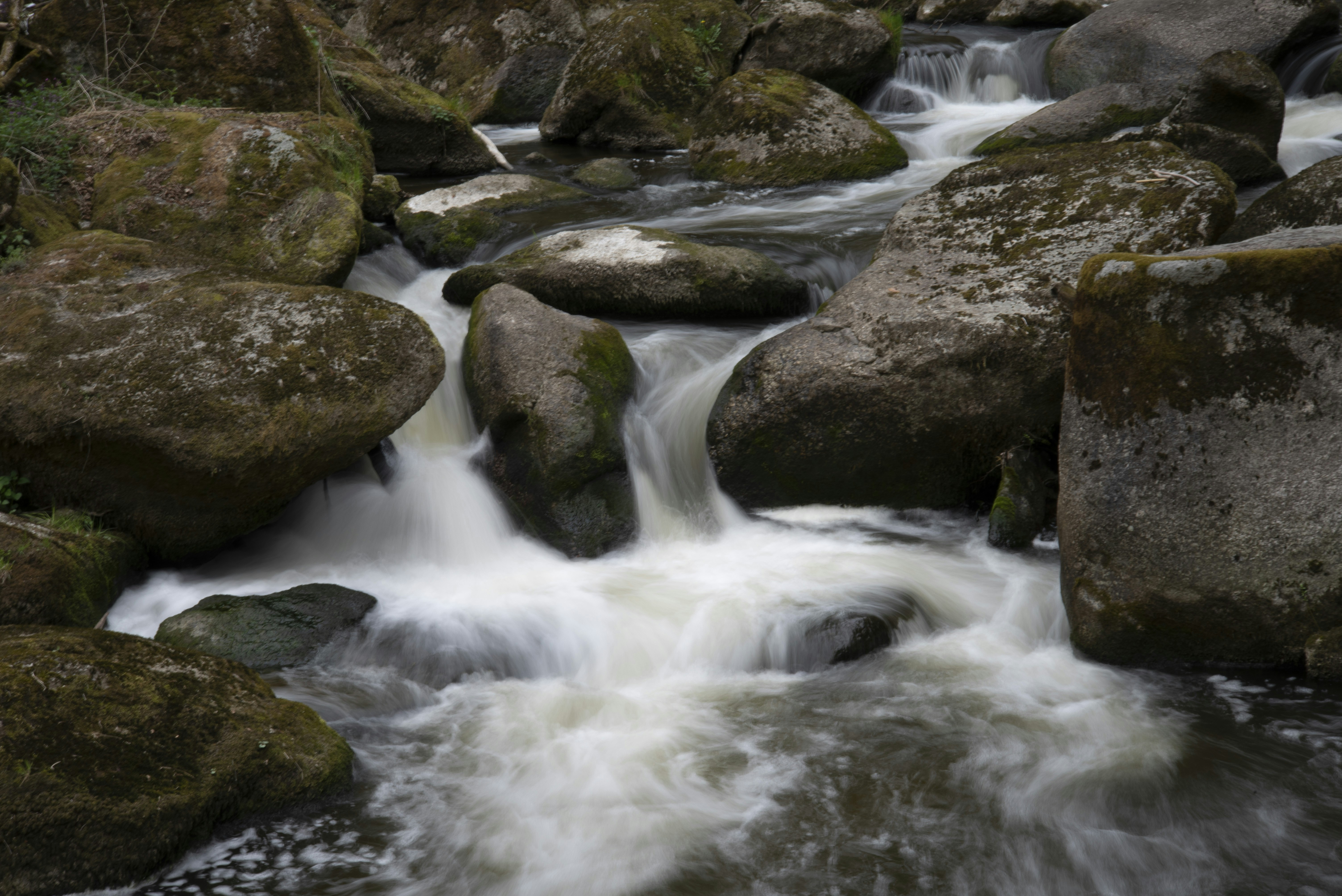 a stream of water running between large rocks