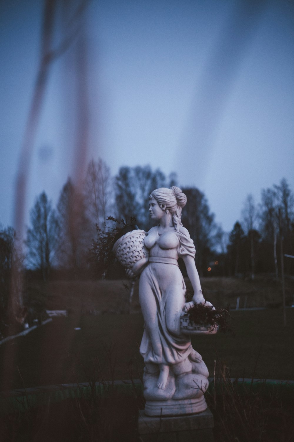 꽃 바구니를 들고 있는 여성의 동상