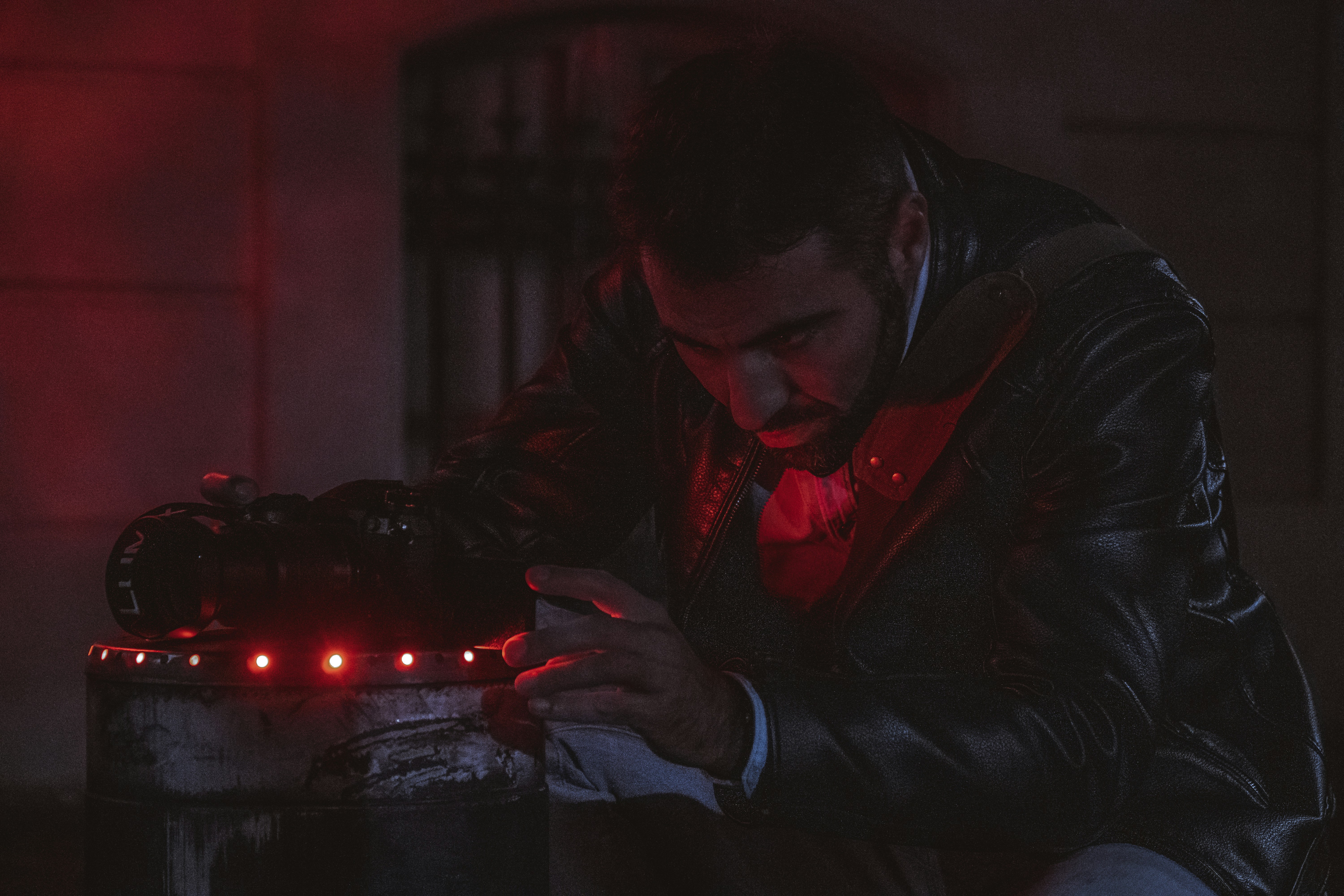 a man in a leather jacket looking at a device