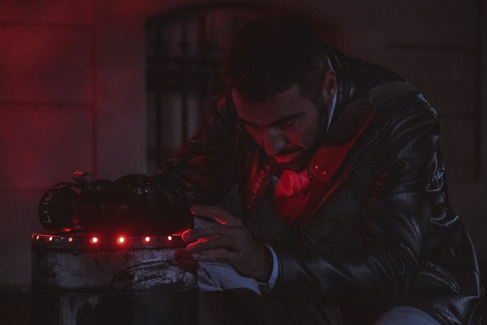 a man in a leather jacket looking at a device