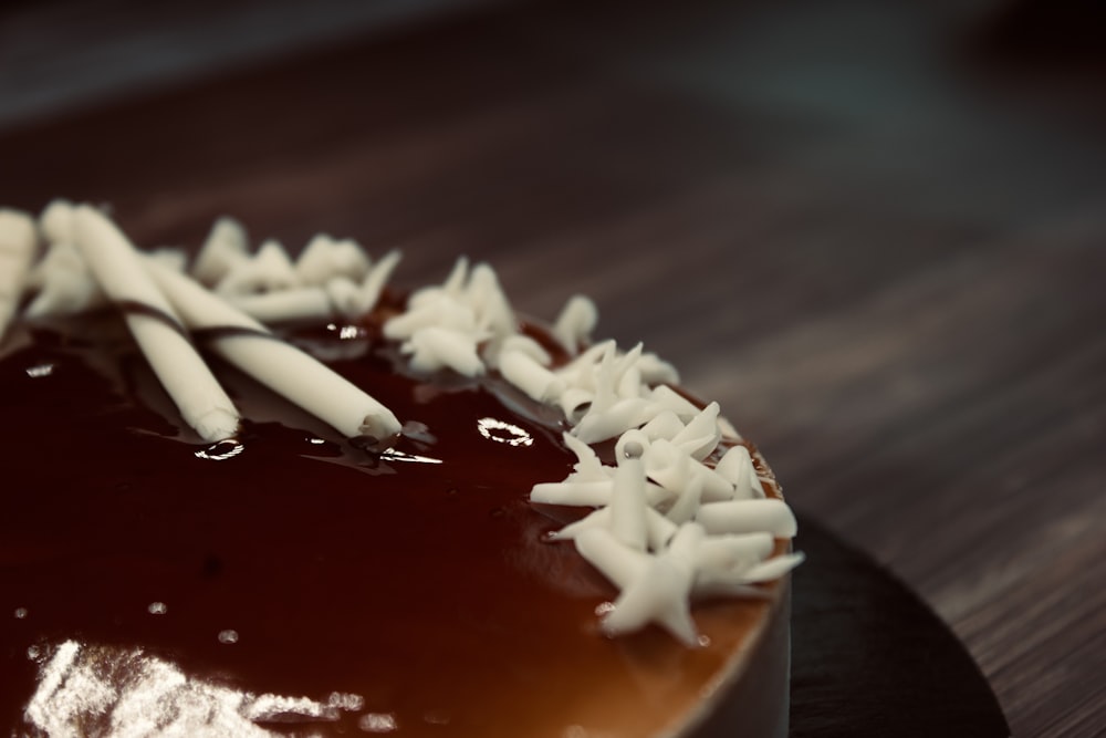 Un pastel de chocolate con glaseado blanco sobre una mesa de madera