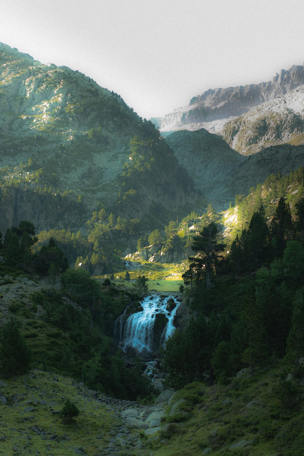 a waterfall in the middle of a lush green valley