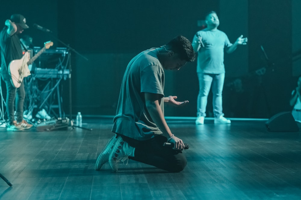 a man sitting on the floor in front of a microphone