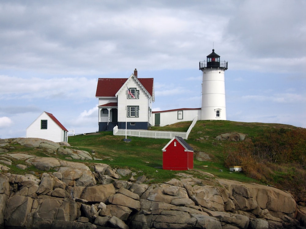 a lighthouse on top of a hill with a red door
