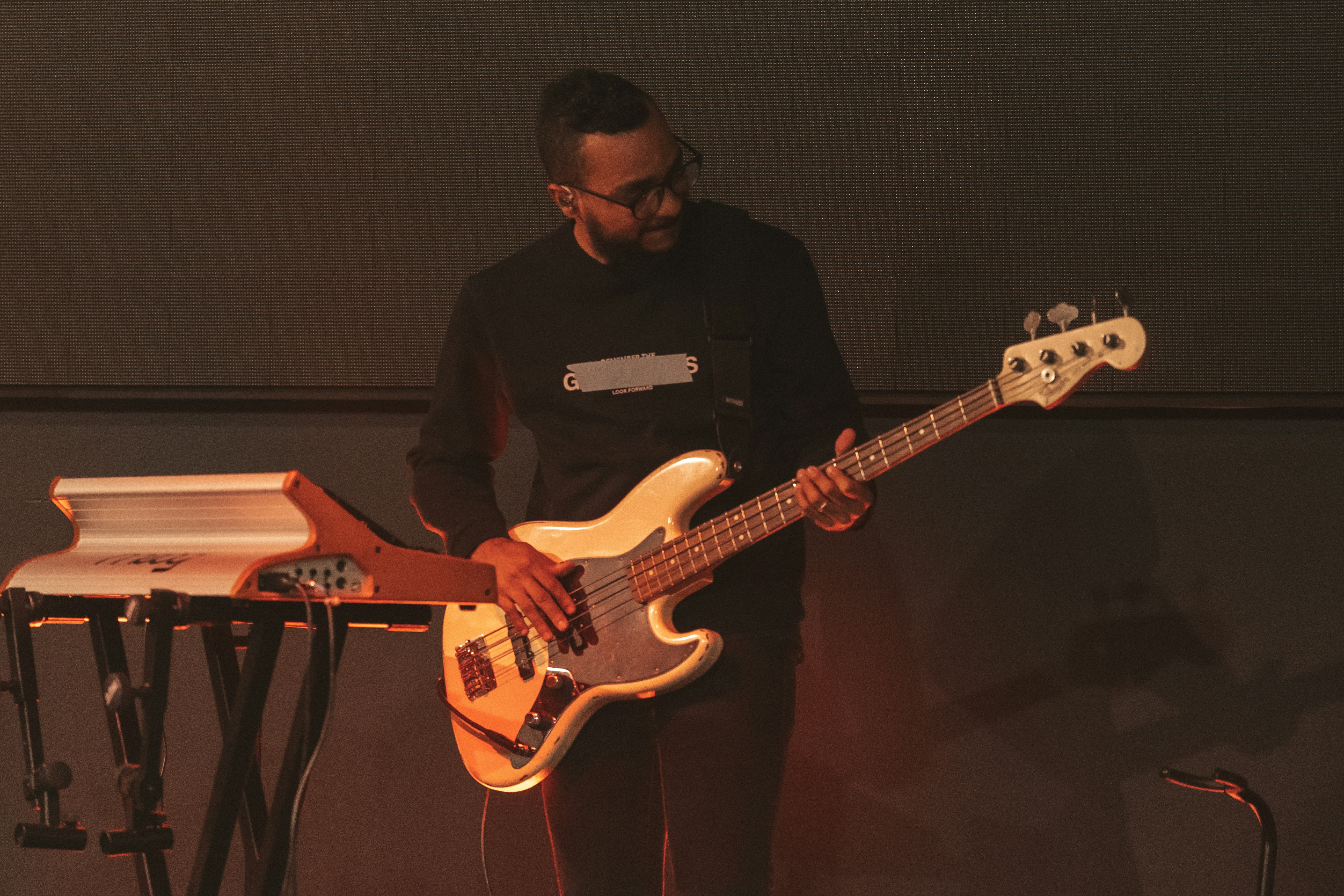 a man standing next to a keyboard and a guitar