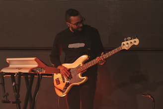 a man standing next to a keyboard and a guitar