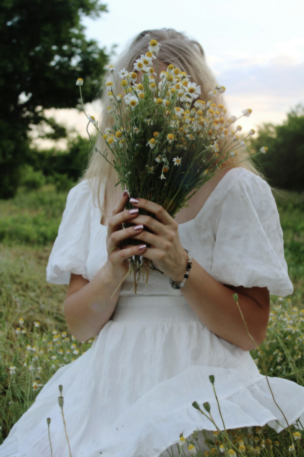 a woman in a white dress holding a bouquet of flowers