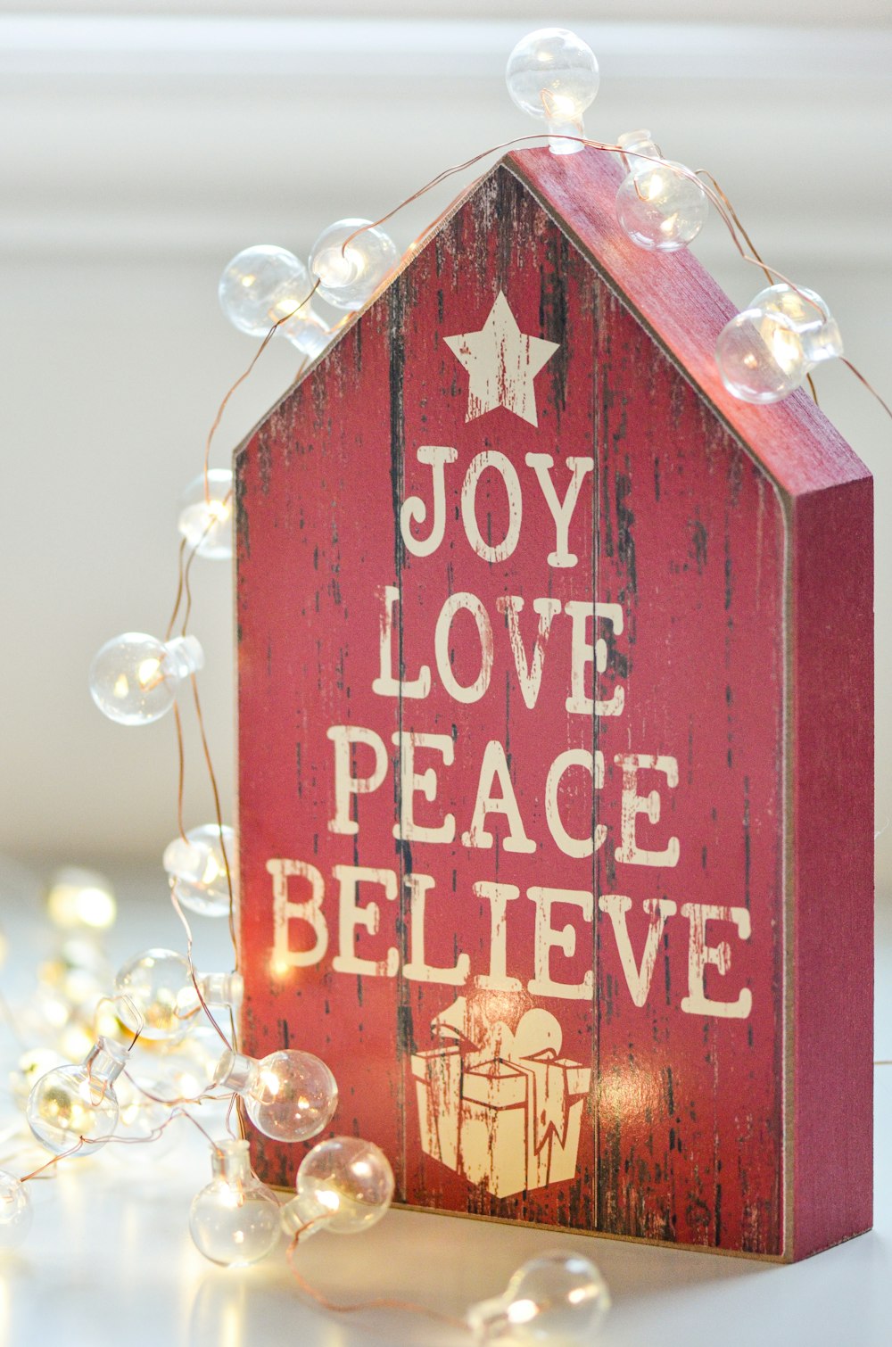 a wooden sign that says joy love peace believe