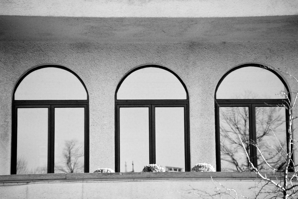 a black and white photo of four arched windows