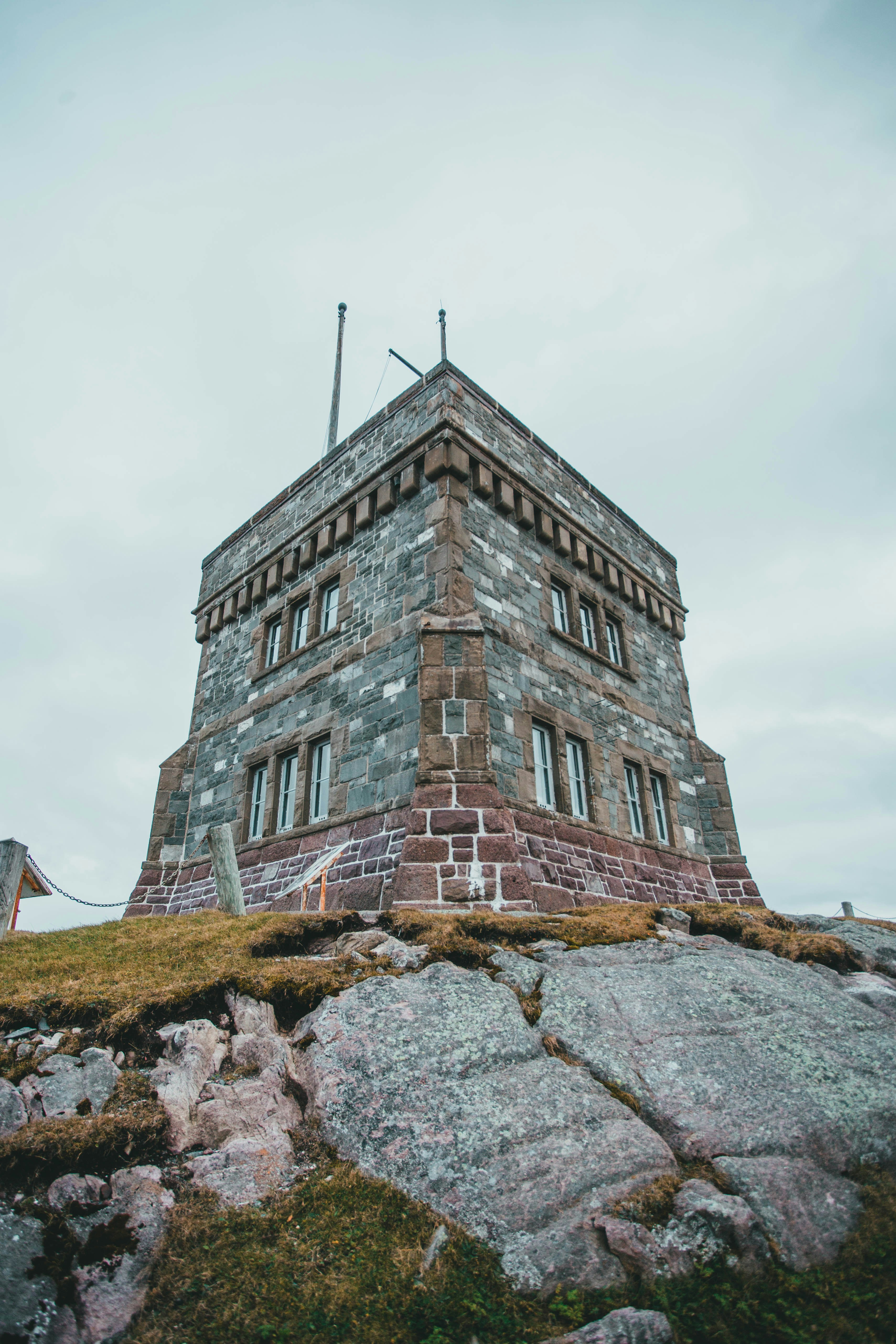 Un grand bâtiment en briques situé au sommet d’une colline verdoyante