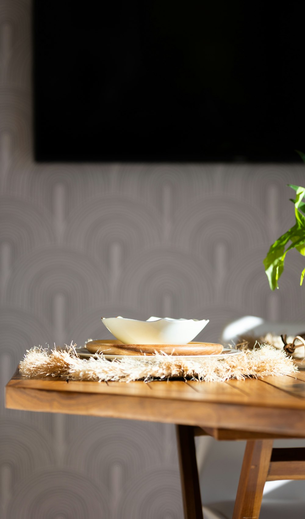 a wooden table topped with a bowl and a plant