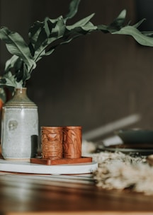 Elegant porcelain vases and lucky gourds displayed on a rustic wooden shelf with warm sunlight.