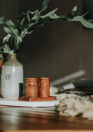 A handmade ceramic vase with subtle glaze sitting on a wooden table.