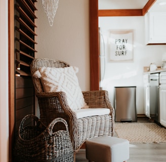 a wicker chair and foot stool in a kitchen