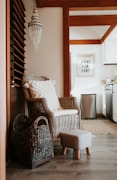 a wicker chair and foot stool in a kitchen