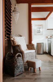 a wicker chair and foot stool in a kitchen