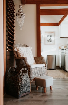 a wicker chair and foot stool in a kitchen
