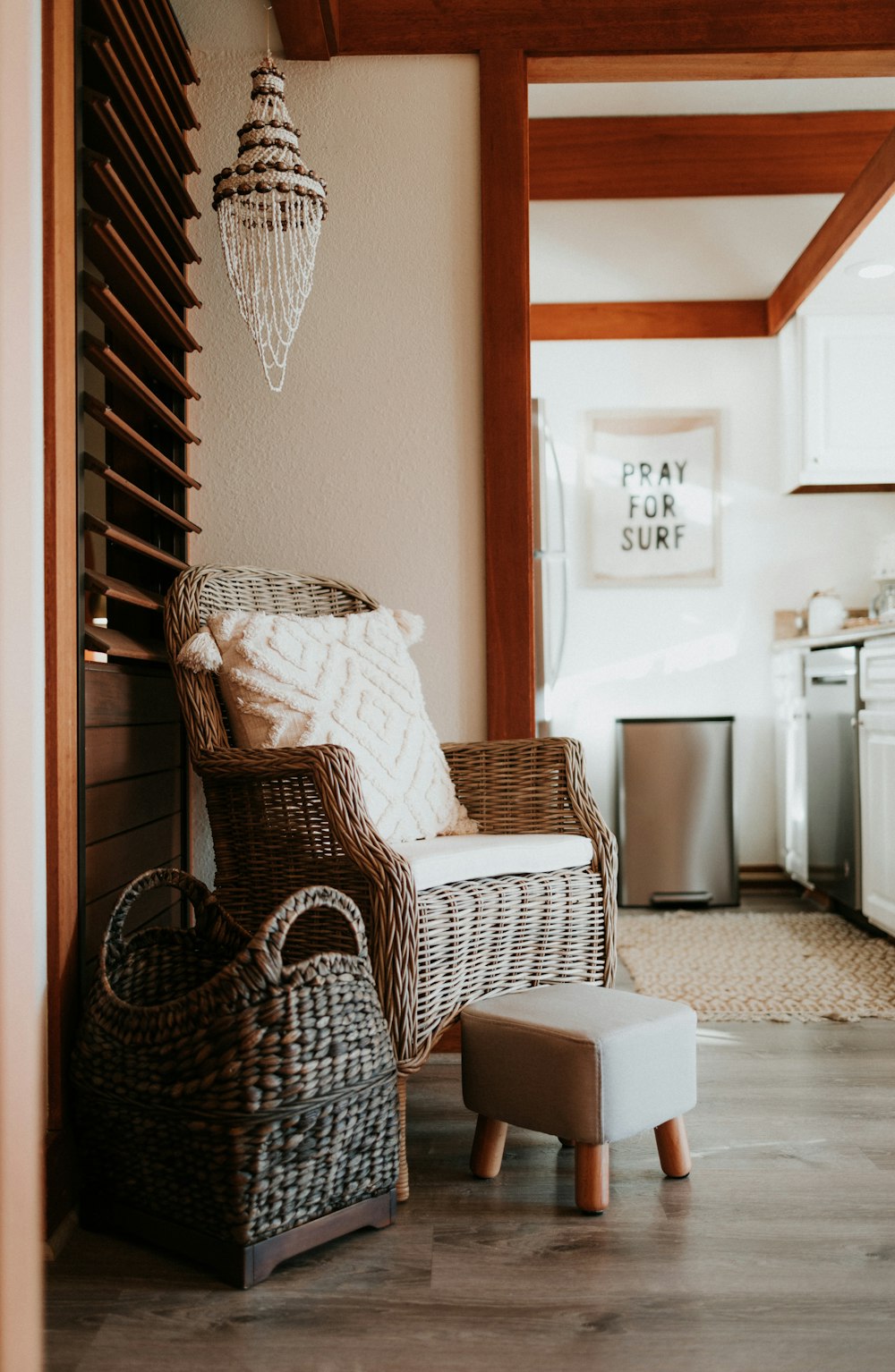 a wicker chair and foot stool in a kitchen