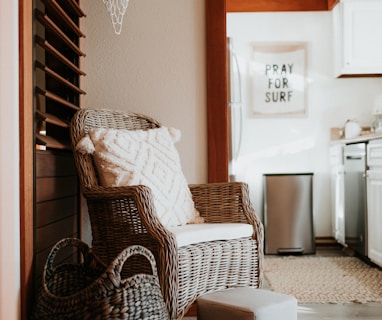 a wicker chair and foot stool in a kitchen