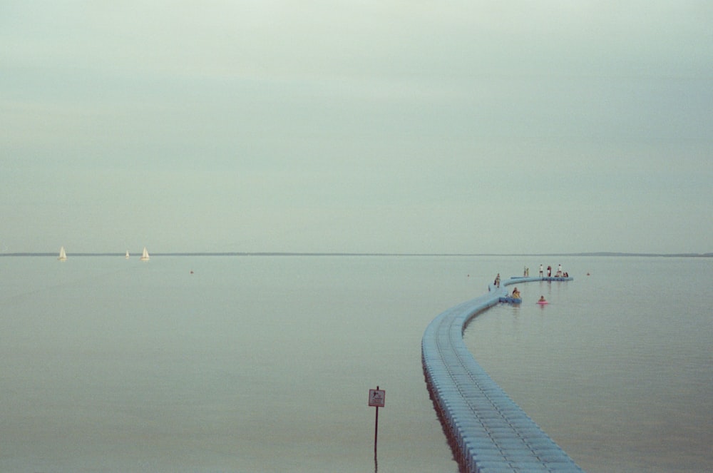 a long pier stretches out into the ocean