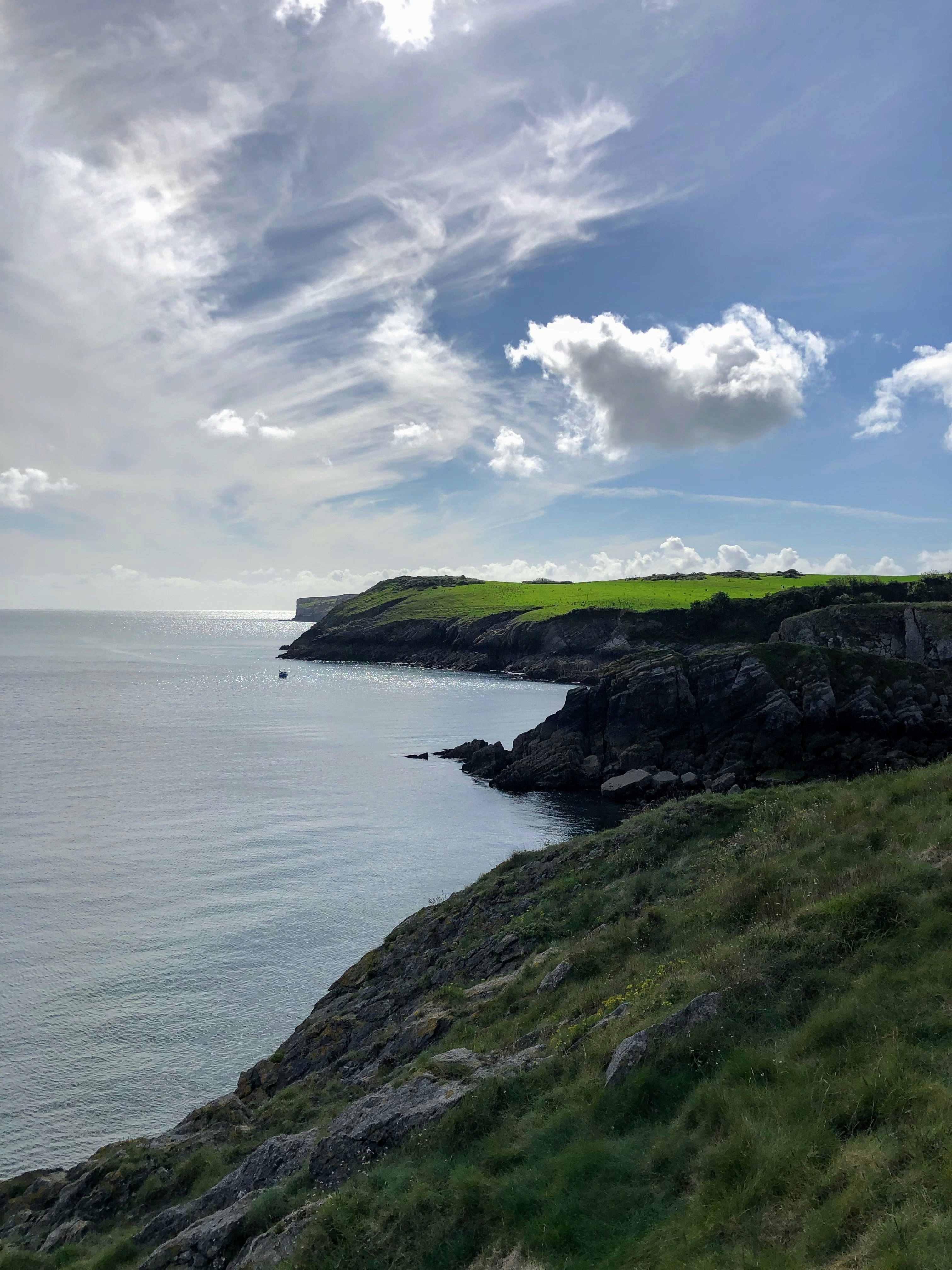 a grassy hill next to a body of water