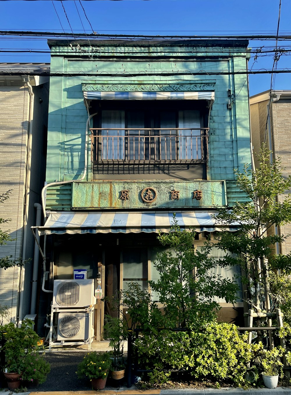 Un edificio azul con toldo rayado