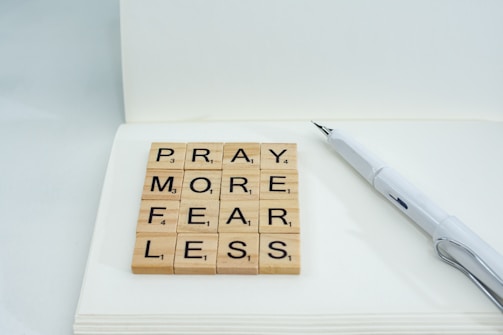 a wooden scrabble that says pray more fear less