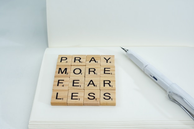 a wooden scrabble that says pray more fear less