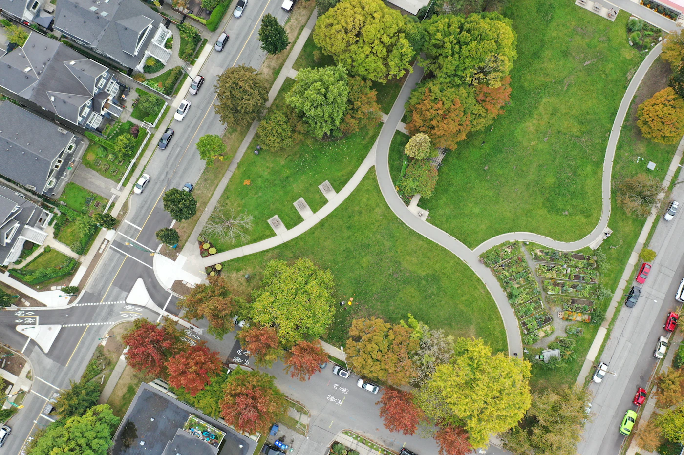 Aerial view of a park with curving paths beside a suburb