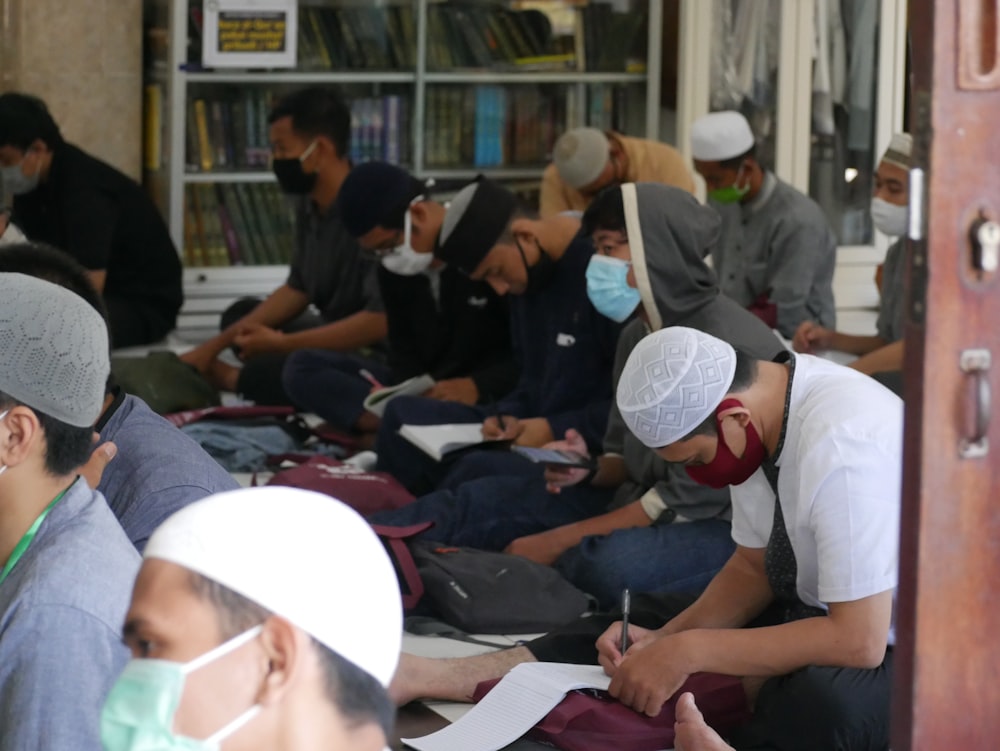 a group of people sitting on the ground in front of a book store