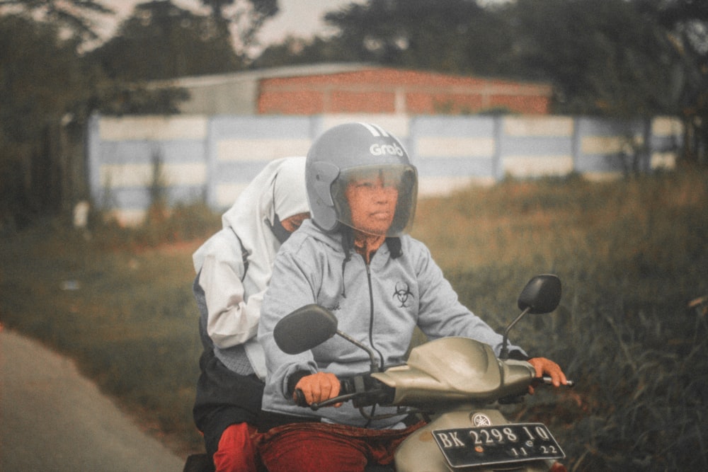 a man and woman riding on the back of a motorcycle
