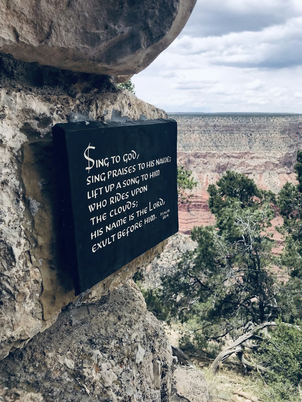 a sign on the side of a cliff that says sing to god